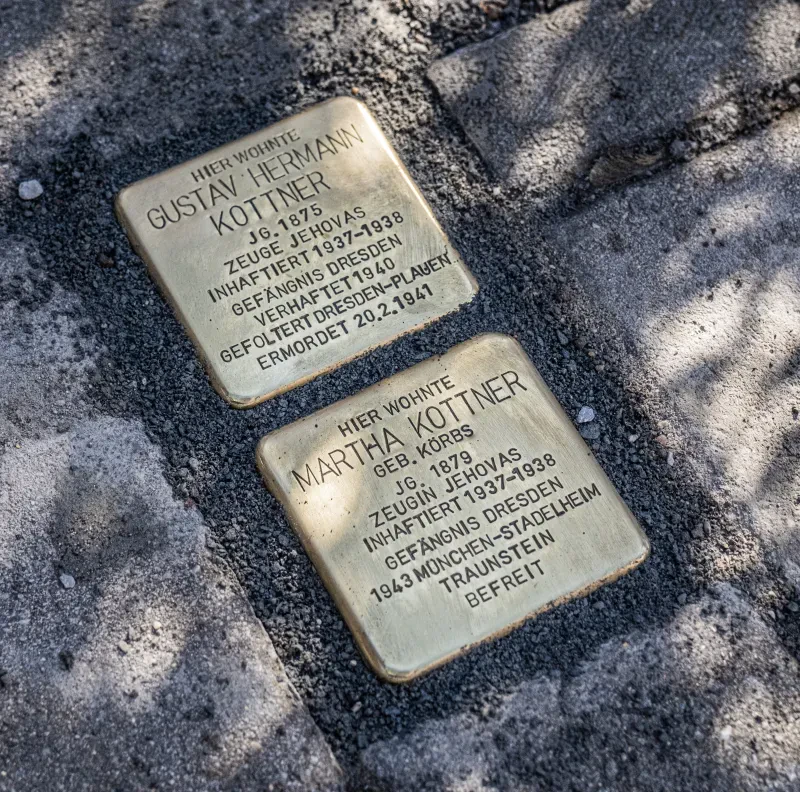 Zwei Stolpersteine mit den folgenden Inschriften: Hier wohnte Gustav Hermann Kottner, Jahrgang 1875, Zeuge Jehovas, inhaftiert 1937 bis 1938, Gefängnis Dresden, verhaftet 1940, gefoltert Dresden-Plauen, ermordet 20.02.1941. Der zweite Stolperstein trägt die Inschrift: Hier wohnte Martha Kottner, geborene Körbs, Jahrgang 1879, Zeugin Jehovas, inhaftiert 1937 bis 1938, Gefängnis Dresden, 1943 München-Stadelheim, Traunstein, befreit.