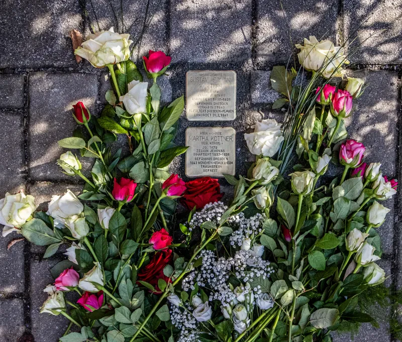 Rote und weiße Rosen schmücken die beiden Stolpersteine für Gustav Hermann Kottner und seine Frau Martha Kottner am Tag der Verlegung.
