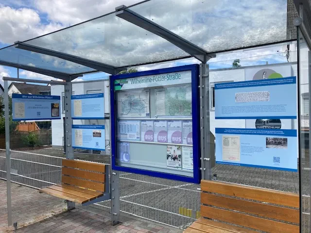 Bushaltestelle Wilhelmine-Pötter-Straße in Niestetal-Sandershausen. Man sieht die Plakate, die über das Leben von Wilhelmine Pötter informieren.
