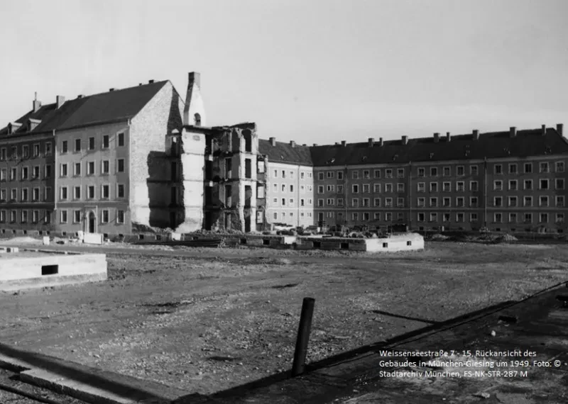 Ansicht mehrerer Wohnblöcke, ein vorderer Teil ist zerstört.