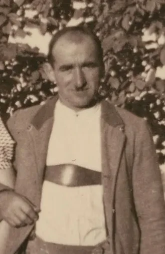 Ein Mann mit Trachtenjacke blickt in die Kamera. Bildausschnitt.