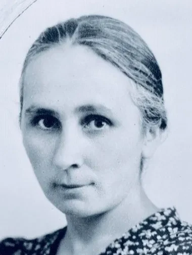 Portrait einer Frau im mittleren Alter mit nach Hinten gekämmtem Haar.