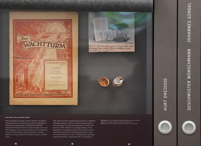 In einem Schaukasten hängen eine Ausgabe des Wachtturms, ein Stasifoto von in einem Brot eingeschmuggelter Literatur und eine geöffnete Walnuss, in deren Schale Miniaturartikel ins Gefängnis geschmuggelt wurde. Rechts daneben sieht man Schuber, die die Verfolgung von Kurt Dreißig, der Geschwister Wünschmann und Johannes Gündel beleuchten.