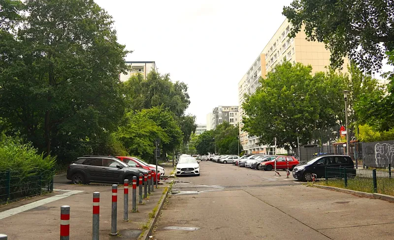 Eine Straße mit parkenden Autos und hohen Wohnhäusern an der Stelle eines abgerissenen Gefängnisses.