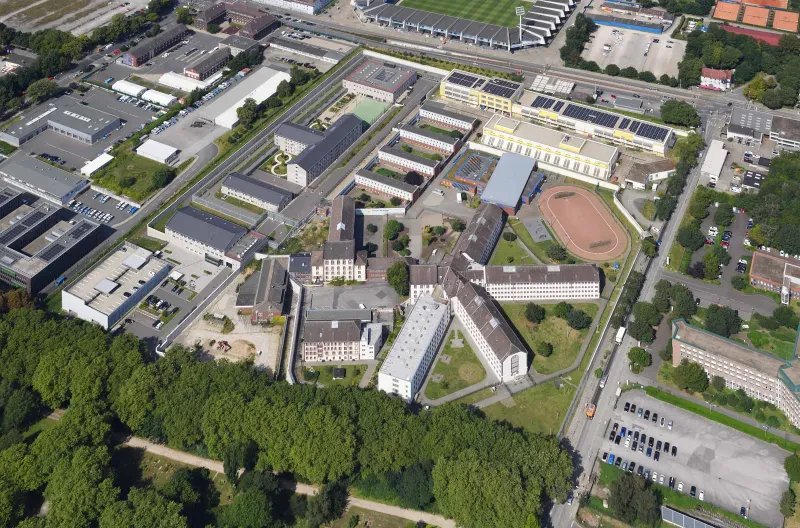Luftbild der JVA Bochum. Man sieht die sternförmig angelegten Hauptgebäude und ein großes eingezäuntes Gelände.