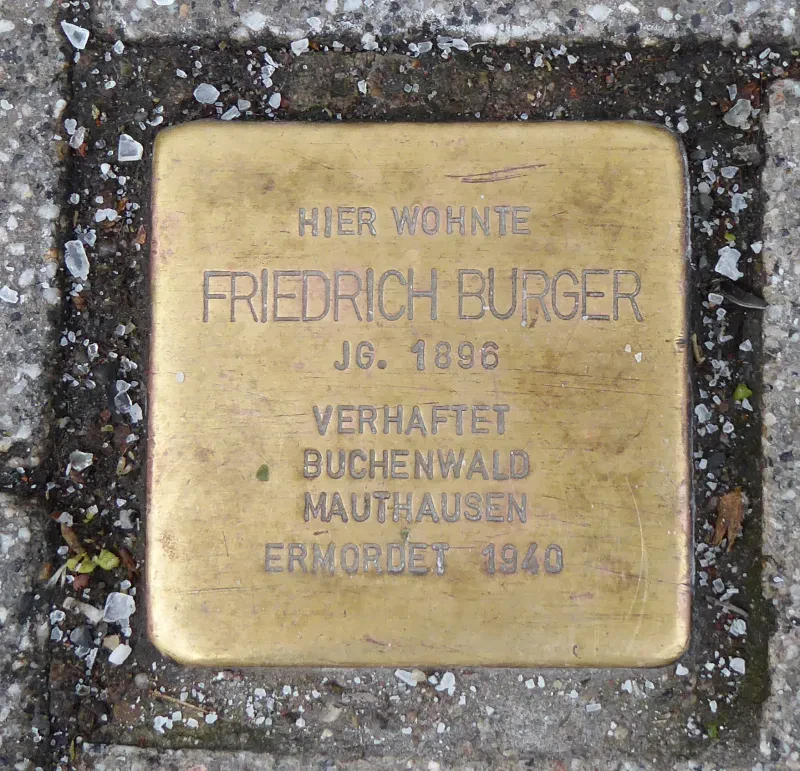 Ein Stolperstein mit der Inschrift: "Hier wohnte / Friedrich Burger / Jg. 1896 / Verhaftet / Buchenwald / Mauthausen / Ermordet 1940"