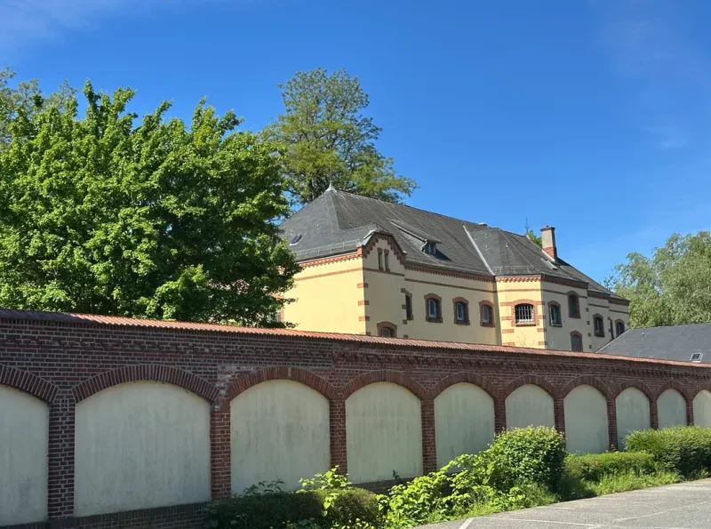Gefängnisgebäude hinter einer Mauer.