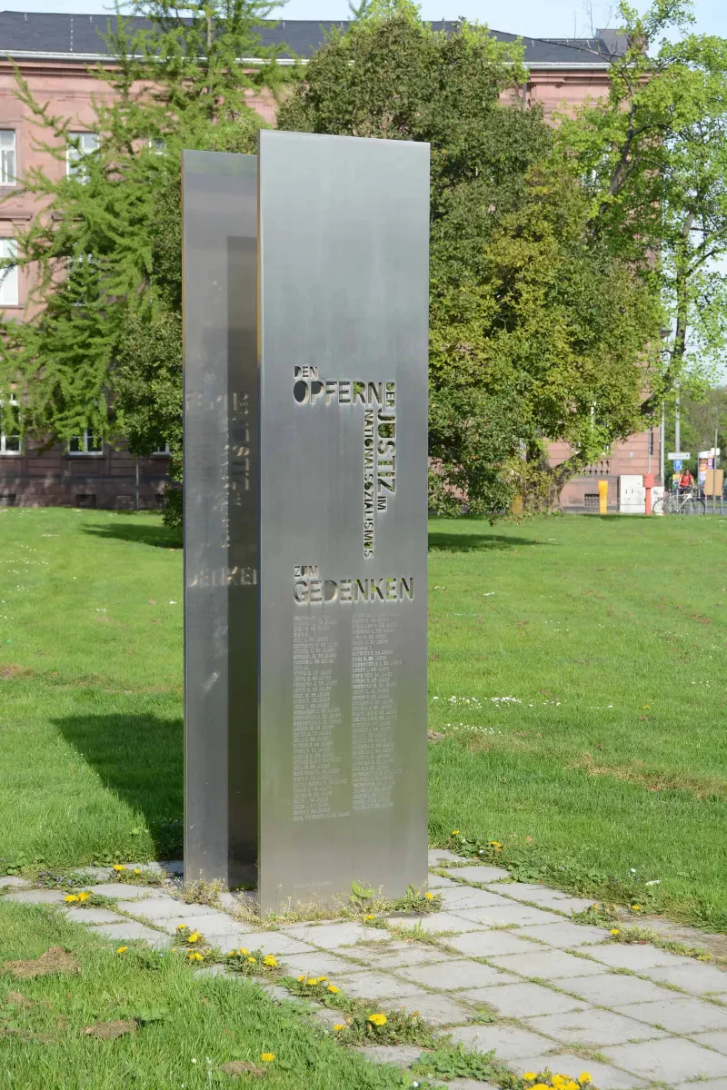 Eine Gedenkstele mit der Aufschrift "Den Opfern der Justiz im Nationalsozialismus zum gedenken" und einer Namensliste.