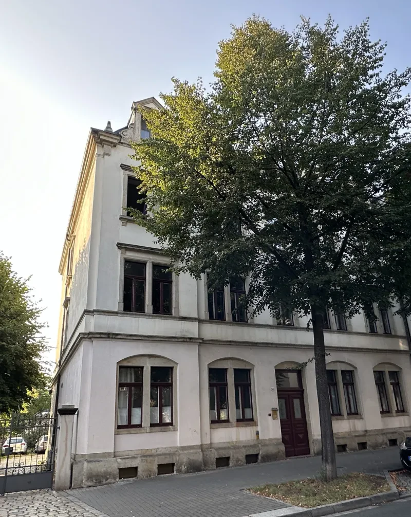 Ein Wohnhaus mit je zwei Doppelfenstern neben der Eingangstür. Im dritten Obergeschoss sind die Fenster im Dachgiebel.