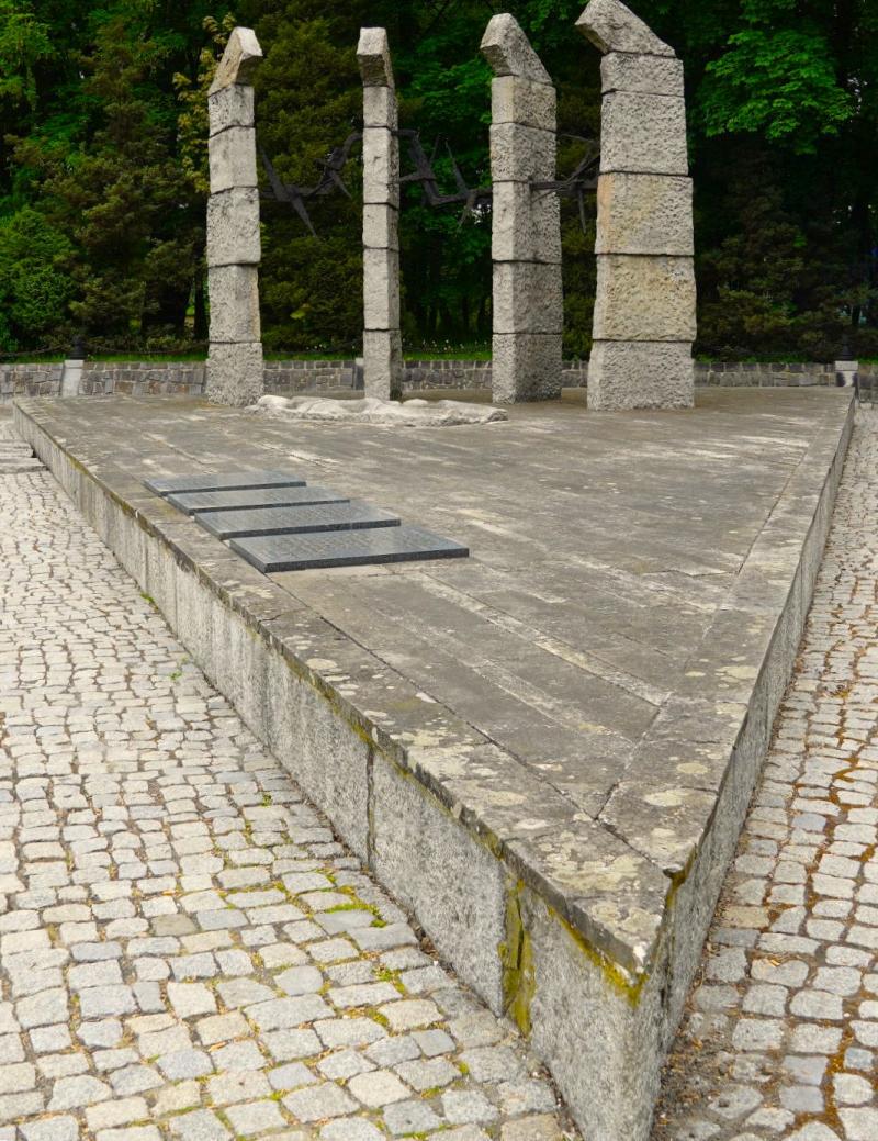 Vier Steinsäulen in Form von Zaunpfählen bilden einen Viertelkreis.