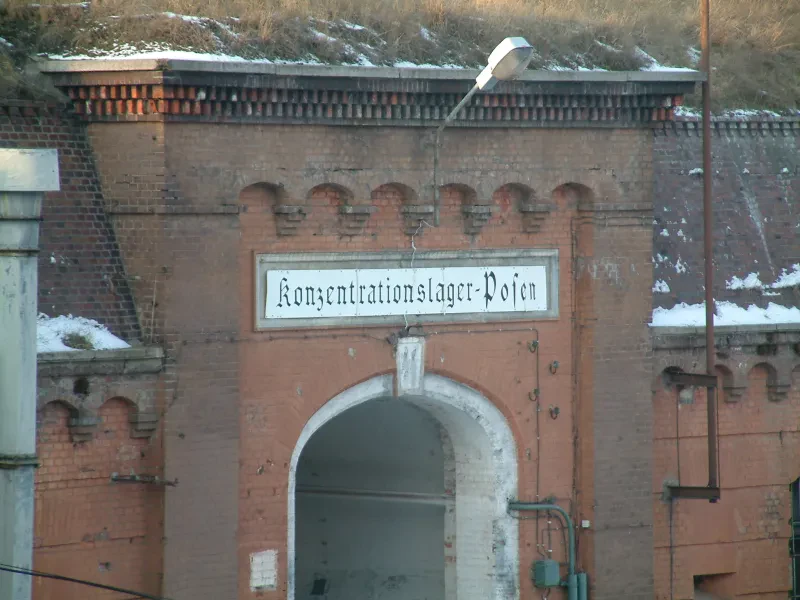 Ein rotes Backsteintor, darüber die Aufschrift "Konzentrationslager-Posen"