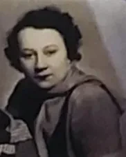 Eine junge Frau im seitlichen Profil blickt lächelt in die Kamera.