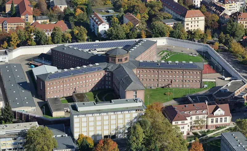 Ein vierstöckiges Gebäude aus roten Backsteinen, dessen fünf Flügel sich in einem turmförmigen Zentrum treffen.