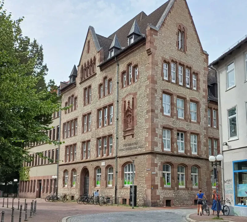 Ein mehrstöckiges Stadthaus, davor mehrere Fahrräder.