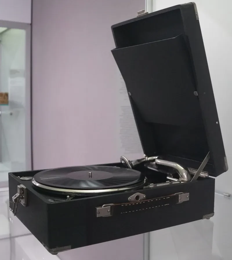 Ein in einem Koffer verbautes Grammophon ist geöffnet und es liegt eine Schallplatte auf dem Gerät.