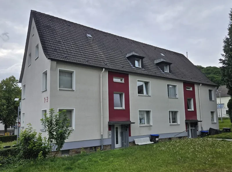 Ein zweistöckiges, hell verputztes Wohnhaus mit Satteldach.
