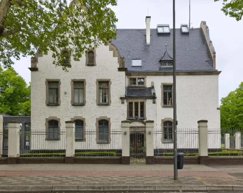 Ein beigefarbenes Kasernengebäude.