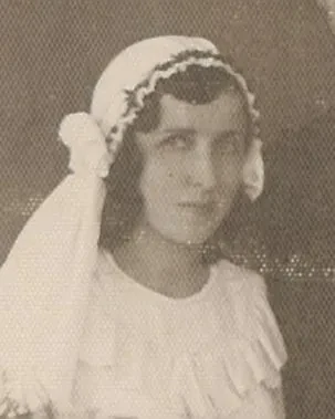 eine Frau mit Brautschleier sieht in die Kamera.