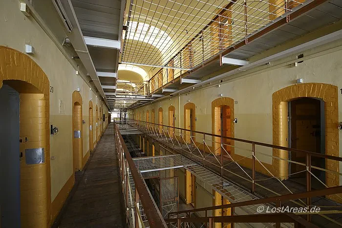 Zwei parallele Gänge führen auf beiden Seiten des Innenhofs im Gebäude zu mindestens zehn offenen Zellentüren.