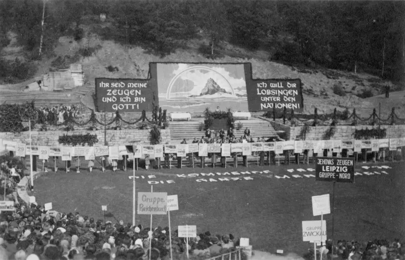 Ein Stadion mit einer Bühne im Hintergrund und Schrift auf dem Rasen.