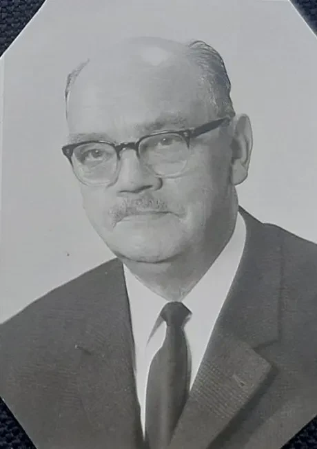 Passbild von einem ca. 70jährigen Mann im Anzug und mit dunkler Brille.