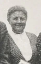 Eine Frau mit Kleid und Bluse hält die Zeitschrift "Der Wachtturm" in der Hand.