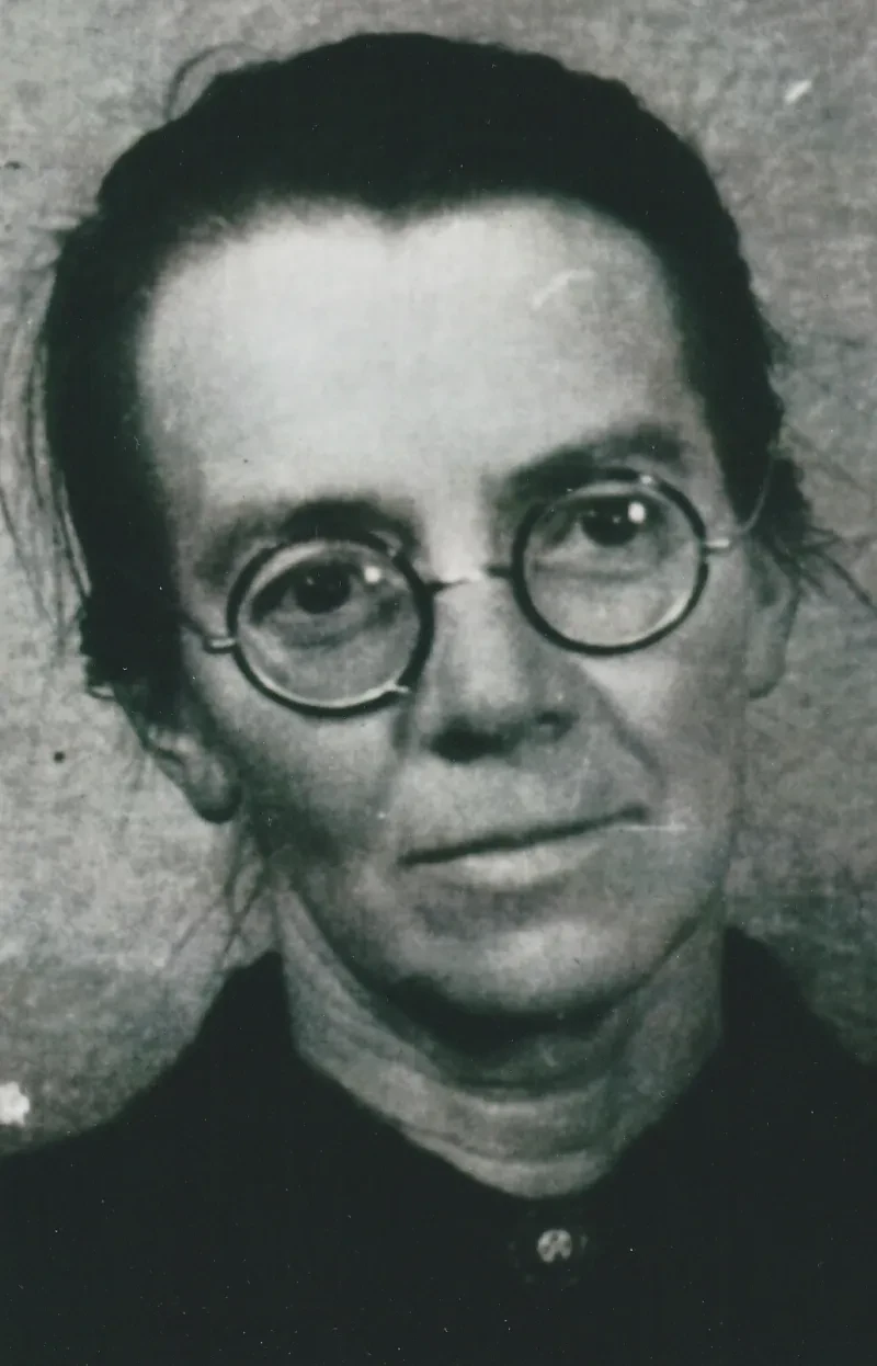 Eine Frau mit runder Brille blickt in die Kamera.