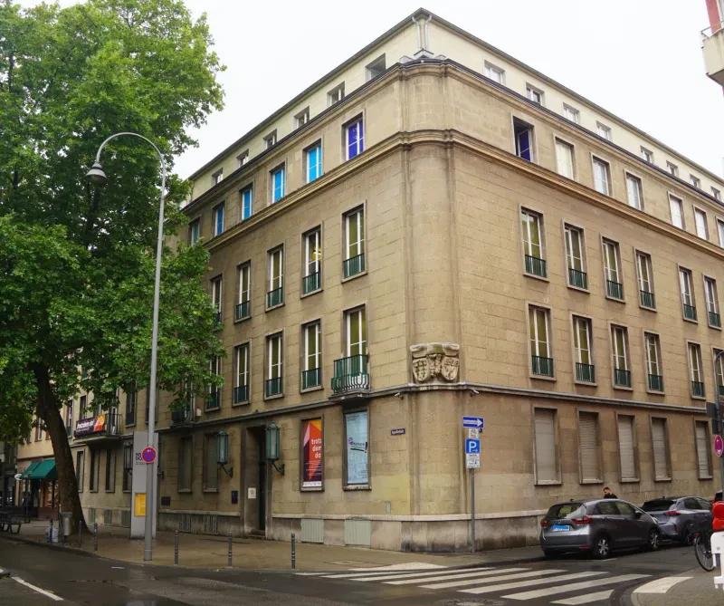 Ein fünfstöckiges Haus mit einer Fassade aus großen Quadern an einer Straßenecke.