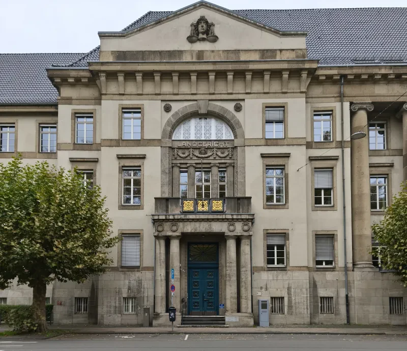 Das Eingangsportal eines grauen dreistöckigen Gebäudes.