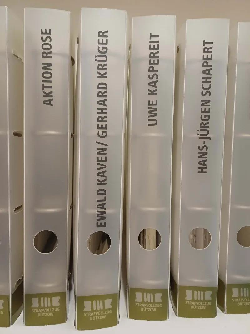 Lesemappen in der Ausstellung über den Bützower Strafvollzug im Krummen Haus in Bützow, darunter auch eine, die über das Schicksal der Zeugen Jehovas Ewald Kaven und Gerhard Krüger informiert, 2024 (Privatarchiv Falk Bersch, Fotograf: Falk Bersch).