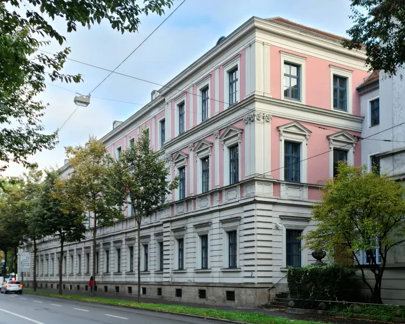 Ein dreistöckiges Justizgebäude an einer Straße.
