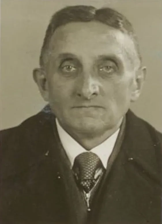 Profilfoto eines älteren Mannes im Anzug.