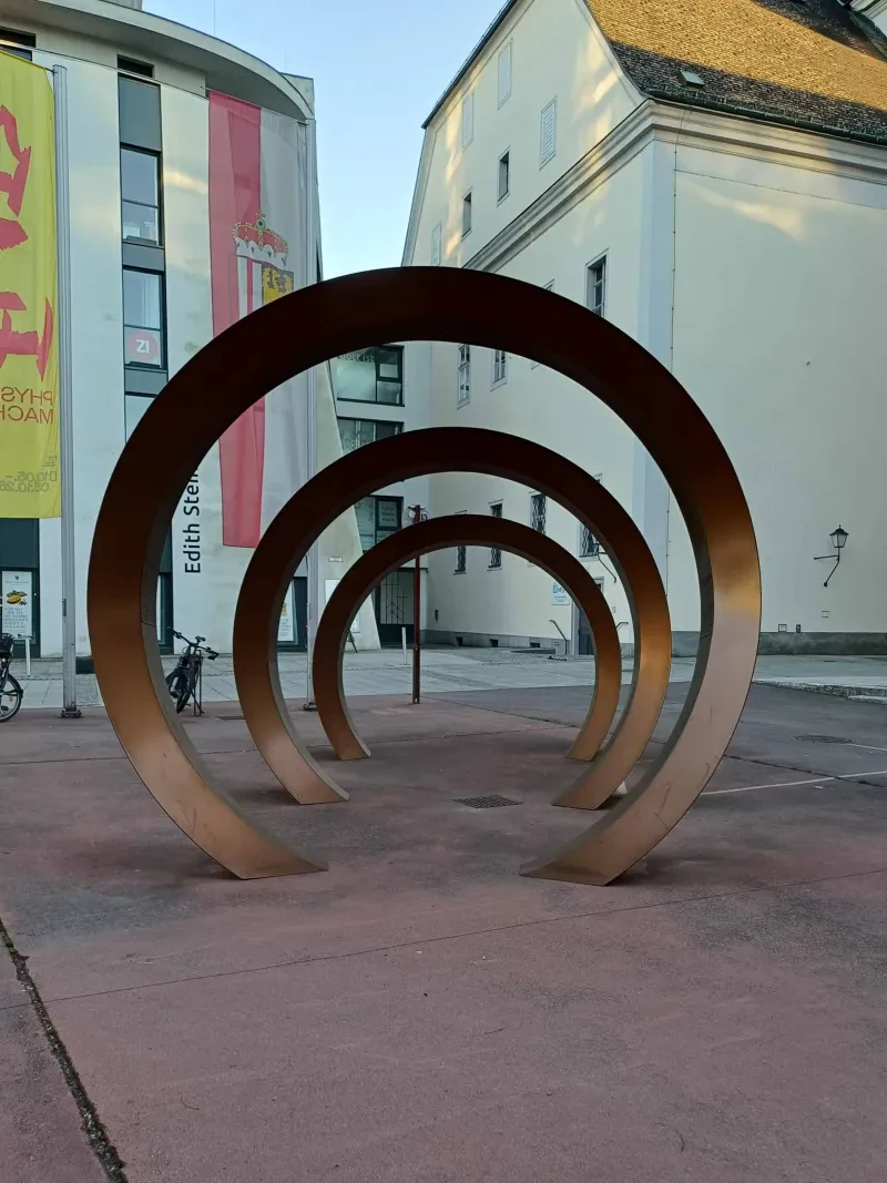 Drei hintereinander stehende Ringe unterschiedlicher Größe stellen drei visualisierte Schallwellen dar.