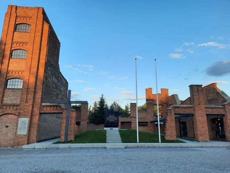 Inmitten der Ruine eines vierstöckigen Backsteingebäudes führt eine Treppe zu einer Plattform, auf der ein dunkler Sarkophag mit der folgenden polnischen Aufschrift steht: "Hier liegen wir, ermordet am Vortag der Freiheit. Das Feuer nahm uns unsere Namen und Körper. Möge ein so unmenschlicher Tod sich nie wiederholen."