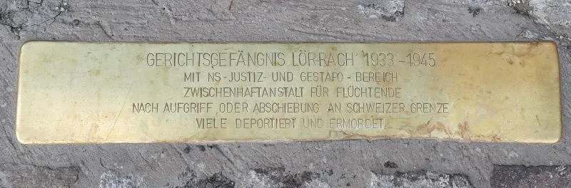 Eine Messingplatte mit der Aufschrift: "Gerichtsgefängnis Lörrach 1933-1945 mit NS-Justiz- und Gestapo-Bereich - Zwischenhaftanstalt für Flüchtende nach Aufgriff oder Abschiebung an schweizer Grenze - Viele deportiert und ermordet".