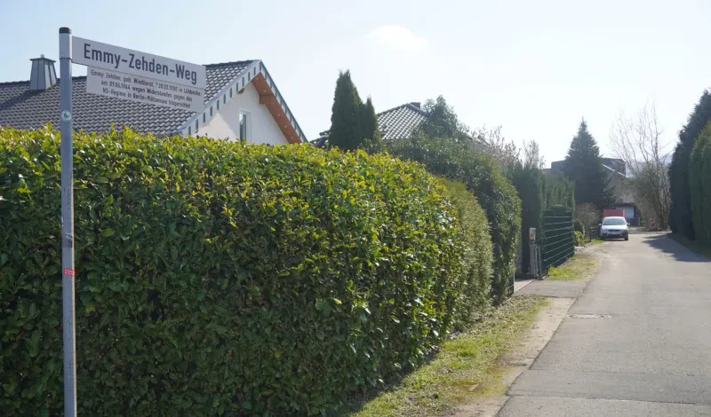 Eine mit Hecken bepflanzte Sackgasse mit dem Straßenschild „Emmy-Zehden-Weg“.