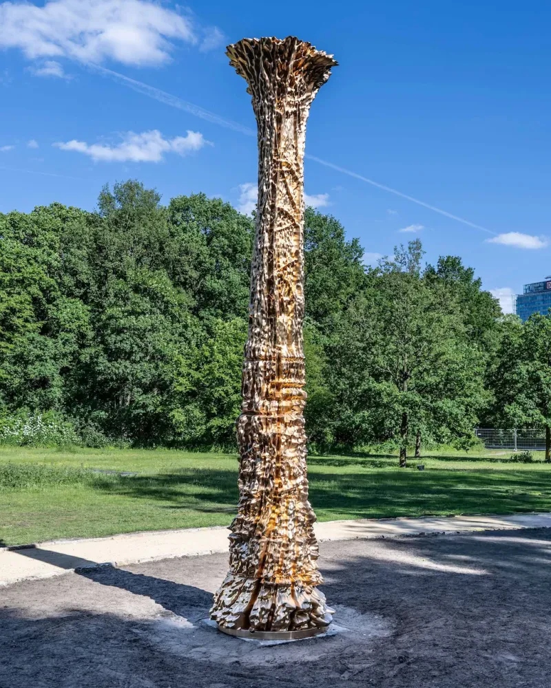 Eine goldene baumähnliche Säule in einem Park.