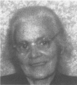 Ein altes Schwarz-Weiß-Foto zeigt eine lächelnde ältere Frau mit grauen Haaren und einer Brille