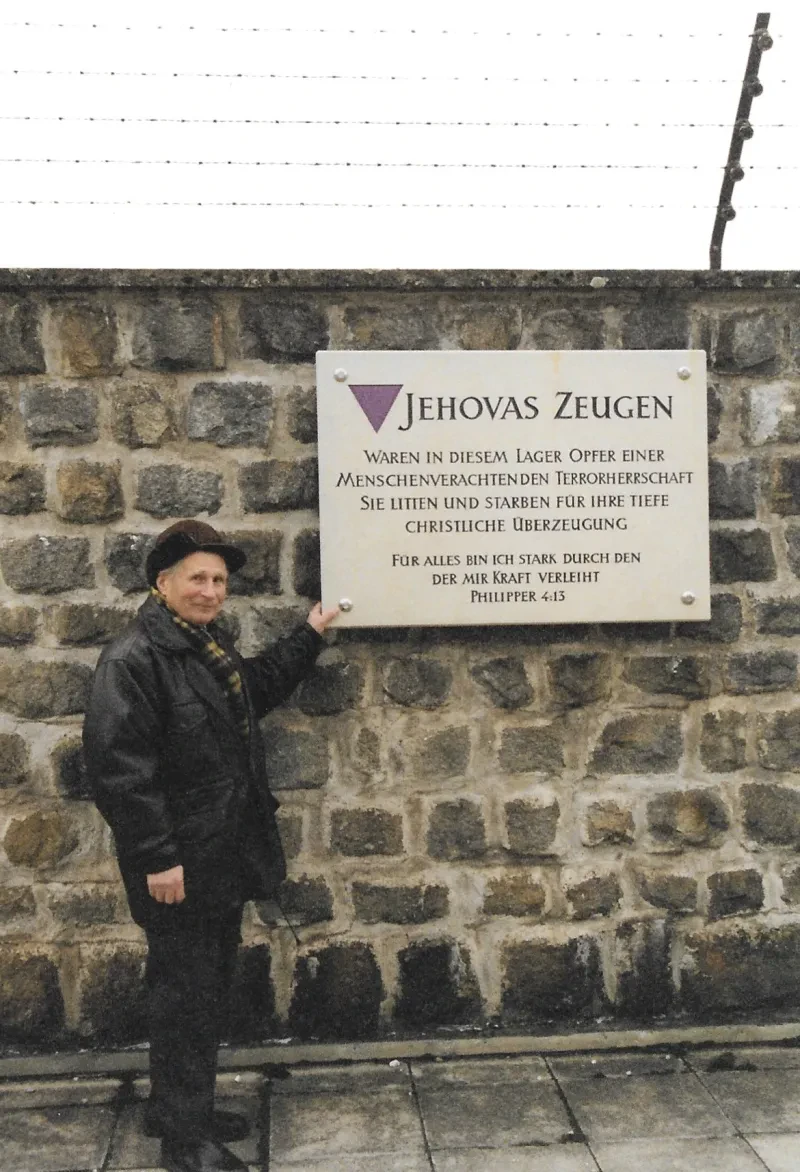 Gedenktafel in der KZ-Gedenkstätte Mauthausen mit dem Zeitzeugen Jan Otrebski, der auch im KZ Mauthausen inhaftiert war, 1999. Der Text lautet: „Jehovas Zeugen waren in diesem Lager Opfer einer menschenverachtenden Terrorherrschaft. Sie litten und starben für ihre tiefe christliche Überzeugung. Für alles bin ich stark durch den der mir Kraft verleiht. Philipper 4:13“