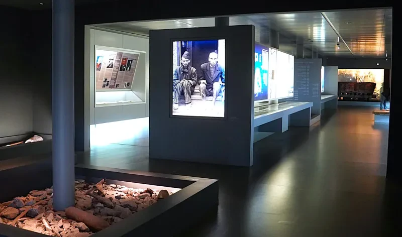 In Kästen auf dem Boden befinden sich Schuttteile aus den Stollen. Auf Schautafeln an der Wand, sowie auf Schautischen befinden sich Fotos und Dokumente der Häftlinge und Täter.