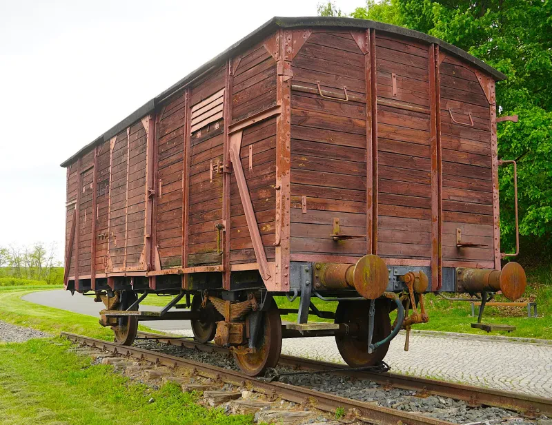 Ein verschlossener, kastenförmiger Güterwaggon aus Holz.