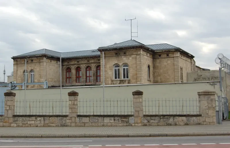 Ein klassizistischer Gefängnisbau hinter einer Mauer.