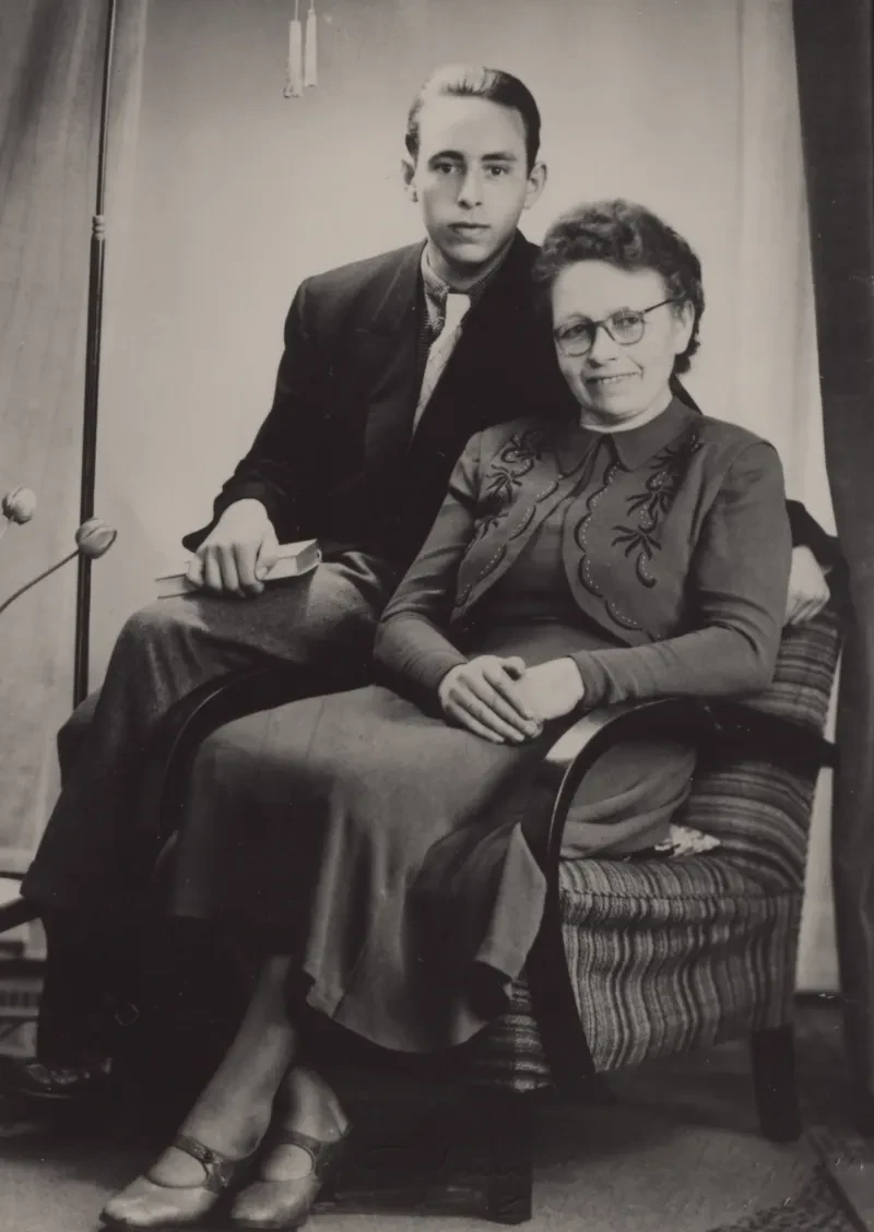 Ein beim Fotografen arrangiertes Foto zeigt Mutter und Sohn. Sie sitzt in einem Sessel, er auf der Lehne und er hält ein Buch in den Händen.