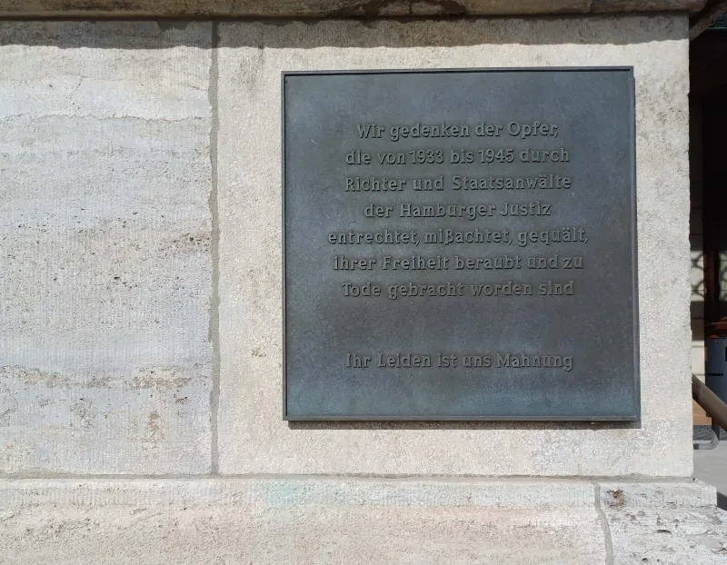 Gedenktafel am Hanseatischen Oberlandesgericht Hamburg, 2024. Text: Wir gedenken der Opfer, die von 1933 bis 1945 durch Richter und Staatsanwälte der Hamburger Justiz entrechtet, mißachtet, gequält und ihrer Freiheit beraubt und zu Tode gebracht worden sind - Ihr Leiden ist und Mahnung