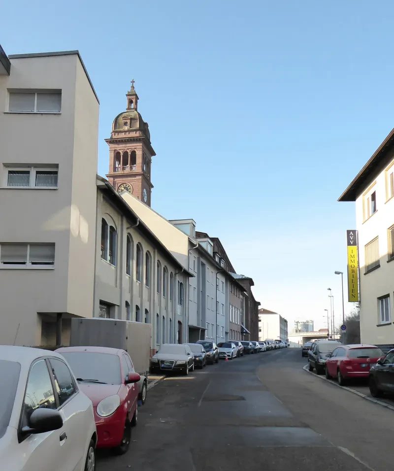 Blick in eine Straße, rechts und links parken Autos, deren Scheiben zugefroren sind.