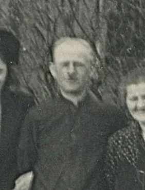 Ein Mann zwischen zwei Frauen blickt in die Kamera, das Bild ist unscharf.
