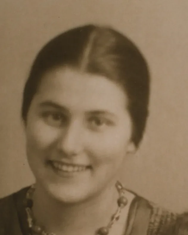Eine junge Frau blickt lächelnd in die Kamera.