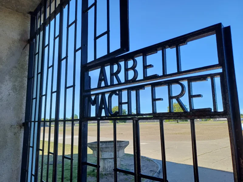 Blick durch das Tor zum Gelände des ehemaligen KZ Sachsenhausen. Am Tor die Inschrift "Arbeit macht frei".
