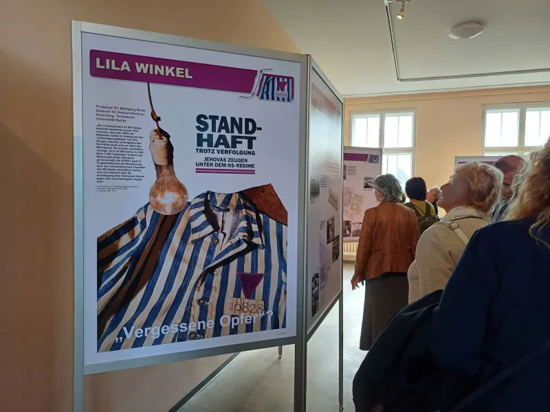 Einige Leute betrachten Tafeln der Ausstellung "Standhaft trotz Verfolgung".