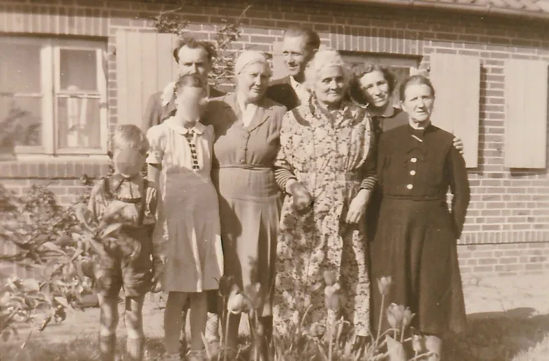 Maria Pomaska (rechts) und Hermann Bonatz (mitte) vor dessen Wohnaus in Schwanheide mit Glaubensgeschwistern vor seinem Wohnhaus, 1950er Jahre.